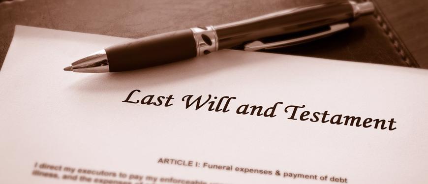 this image shows a last will and testament on a desk with a pen.